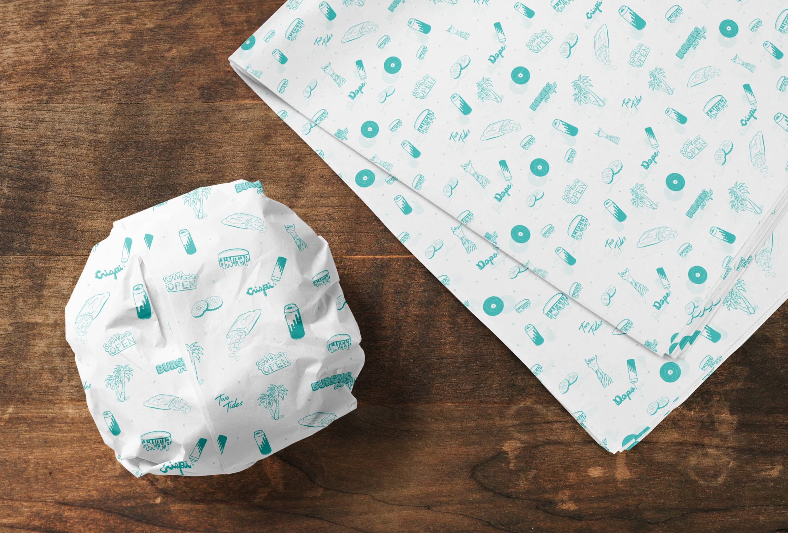 Brand pattern design for Two Tides Crispi by Olive Ridley Studios: custom printed deli paper sitting next to a wrapped burger