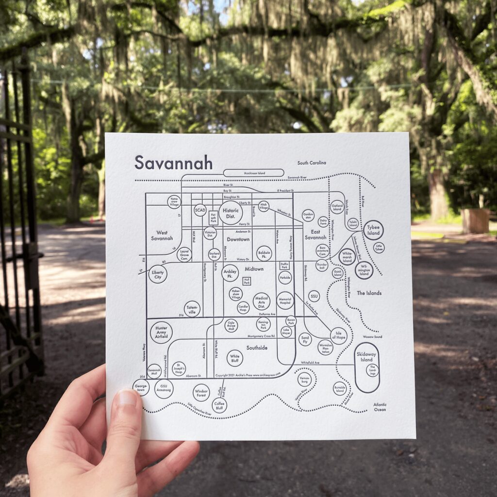 Map of Savannah created through a collaboration between Olive Ridley Studios and Archie's Press: Letterpress-printed map being held in front of the entrance to Wormsloe Historic Site