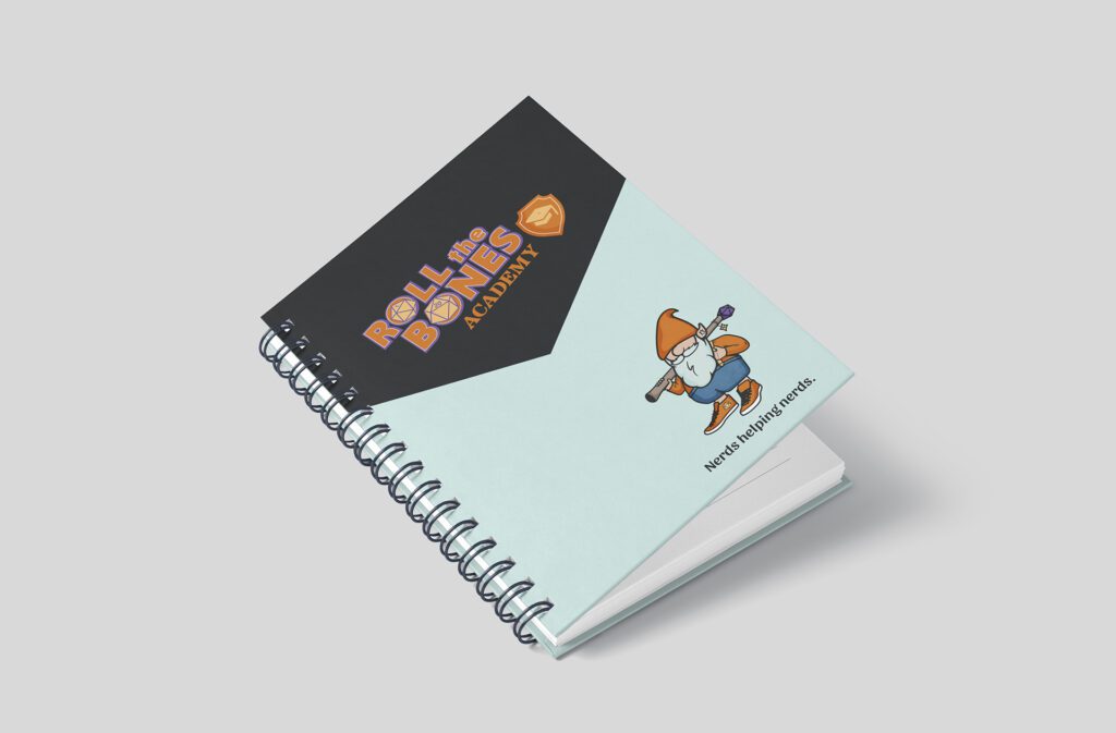 Visual brand identity design created for Roll The Bones by Olive Ridley Studios - Academy logo and gnome mascot mocked up on a notebook