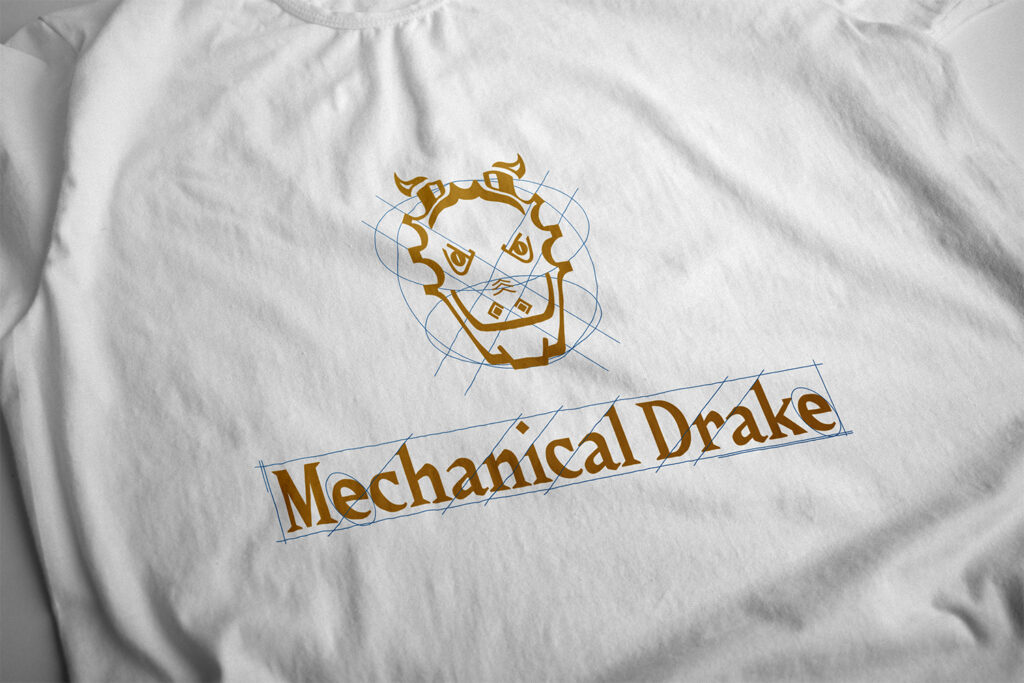 Mechanical Drake t-shirt mockup. White t-shirt with a gold and blue logo featuring a drake's head mascot, serif typography, and sketch lines.